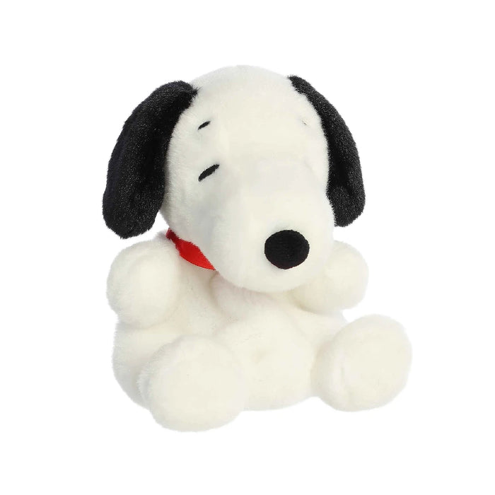A plush dog wearing a red collar, positioned on a white surface, highlighting its adorable features and friendly demeanor.