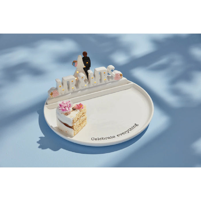 A white plate with the inscription "Celebrate Everything" artistically arranged.
