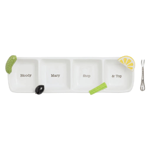 A white tray holds a green and yellow cucumber slice alongside a silver spoon.