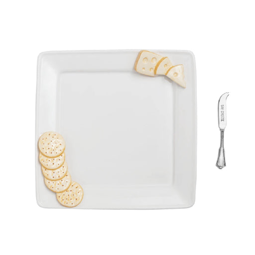 A square plate holds an assortment of crackers and slices of cheese arranged neatly.