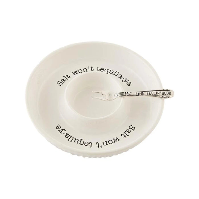 A fork and spoon rest on a plate beside a bowl of steaming soup.