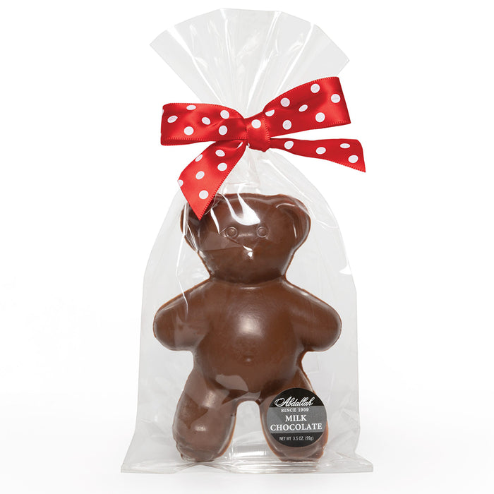 Chocolate bear in a clear bag with a red polka dot bow on a white background