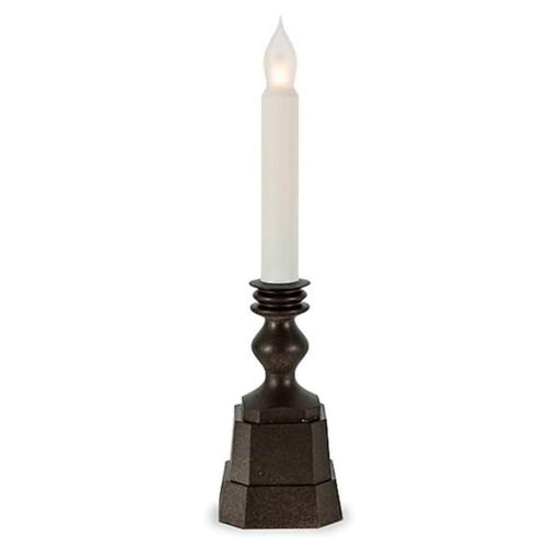 Decorative candle holder with a white candle on a white background