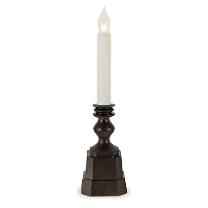 Decorative candle holder with a white candle on a white background