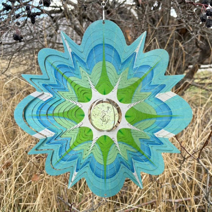 A green and blue flower made from paper cutouts, displaying a creative and colorful floral design.