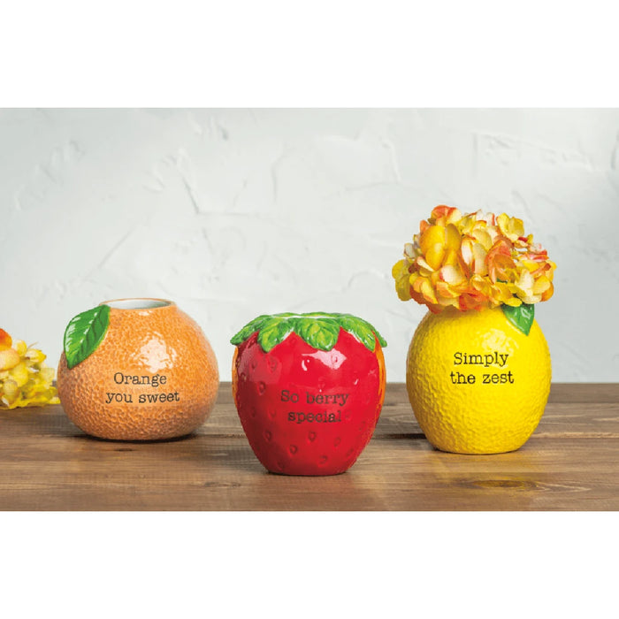  A decorative vase shaped like a lemon, adorned with colorful flowers, adding a lively touch to the setting.