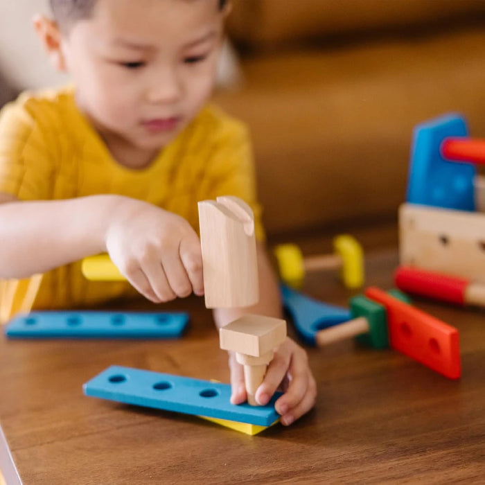 A wooden toolbox with tools and bright toys inside, representing a fusion of practical tools and playful items.
