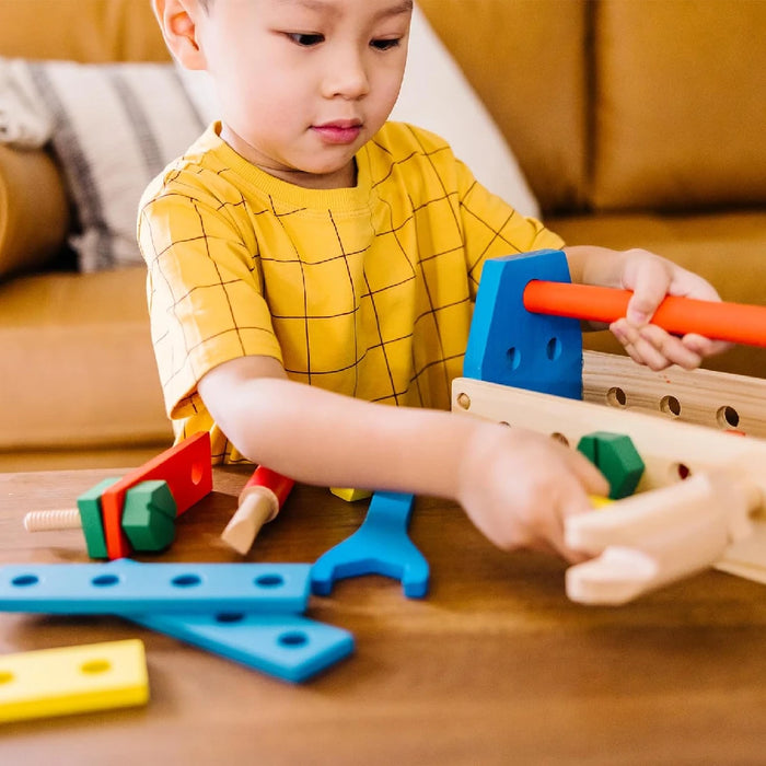 A wooden tool box featuring tools and colorful toys, emphasizing a creative blend of utility and entertainment.