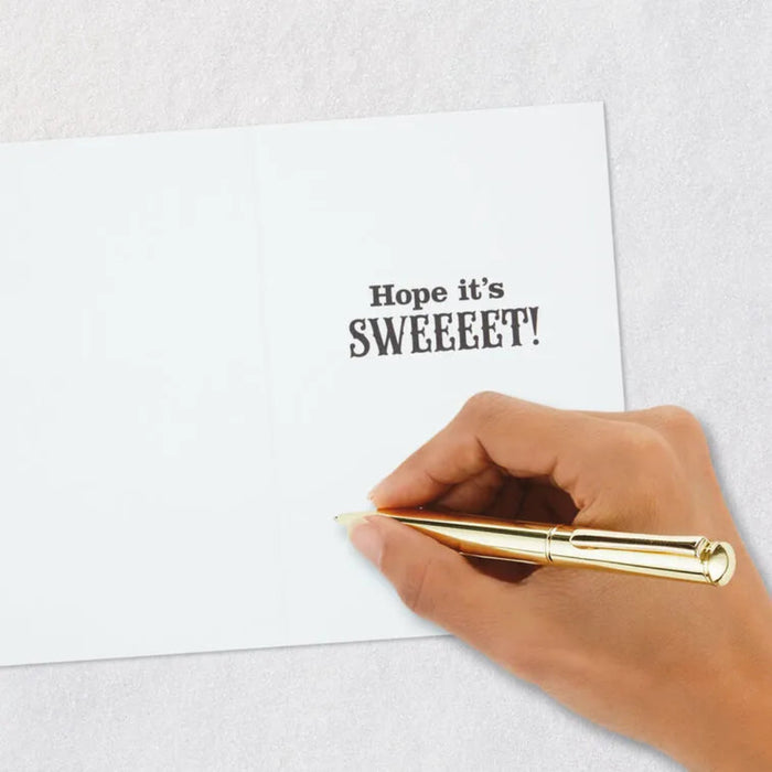 Hand holding a gold pen over a letter with 'Hope it's SWEEEEEET!' text.