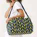 Person holding Vera Bradley Miramar Weekender in Daffodils – quilted cotton floral weekender bag with spacious interior and zipper closure