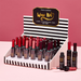 Display of 'Wine Not?' lip tint bottles with a striped box on a pink - background. Assorted chosen at random 