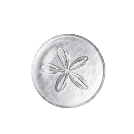 A white plate featuring an intricate sand dollar design in the center.