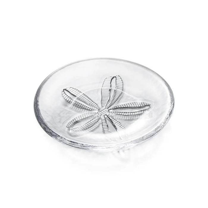 A white plate displaying a sand dollar design, emphasizing coastal themes.