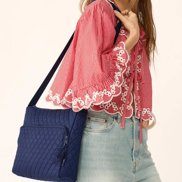 Quilted navy blue bag equipped with a zipper.