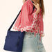 Quilted navy blue bag equipped with a zipper.