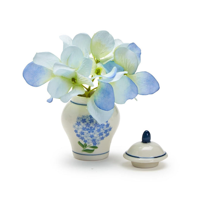 A decorative blue and white vase showcasing a bouquet of blue flowers, adding a touch of color to the setting.