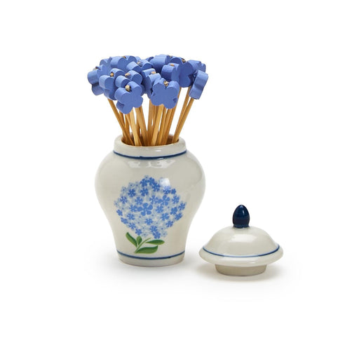 A blue and white vase filled with vibrant blue flowers, elegantly displayed against a neutral background.