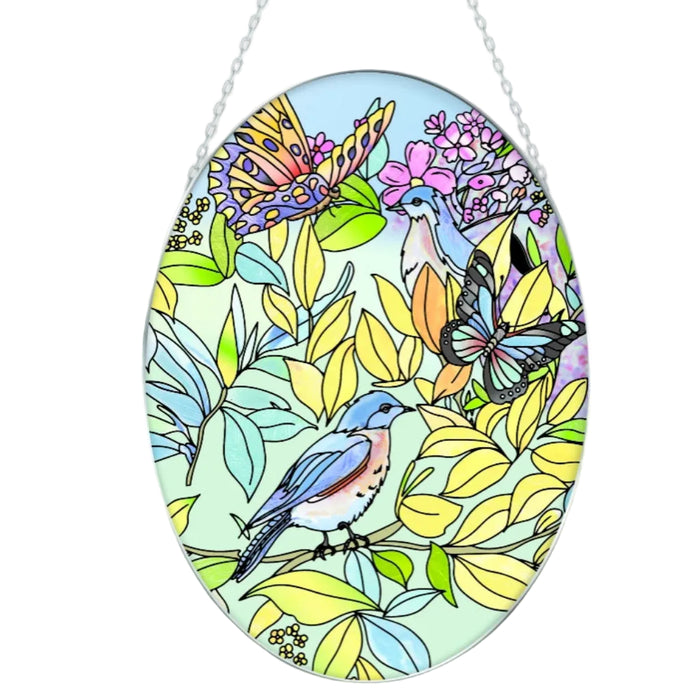 This Bridgeton Hall Bluebirds and Butterflies Medium Oval Suncatcher brings a delightful combination of birds, butterflies, and nature-inspired beauty to your home décor.