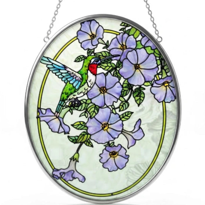 Bridgeton Hall Hummingbird Garden stained-glass-style suncatcher measuring 7 by 5.5 inches, featuring a colorful hummingbird surrounded by blooming flowers hanging in a sunny window.