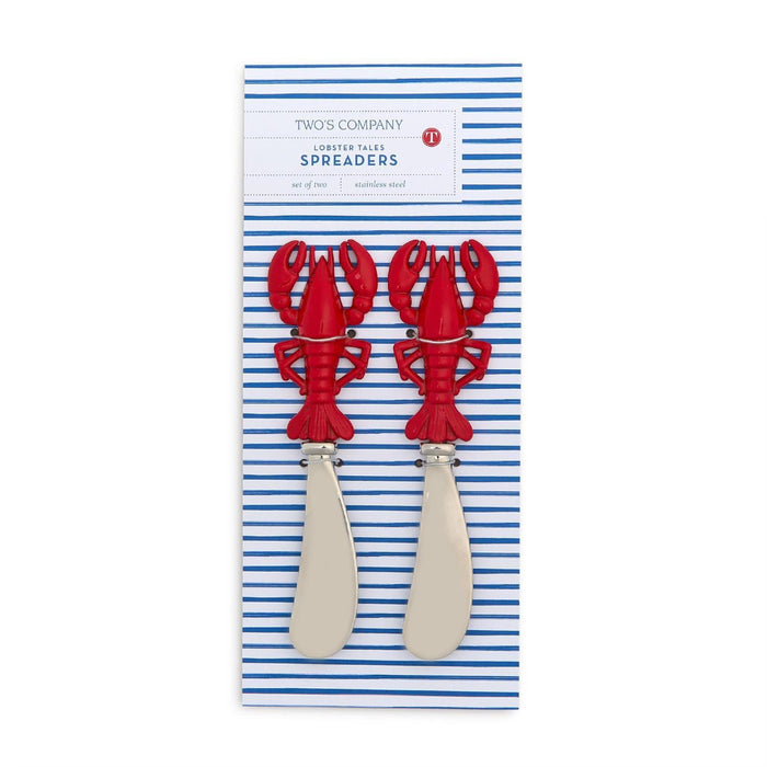 Two red lobster-shaped cutlery pieces rest on a striped tablecloth, adding a playful touch to the dining setting.