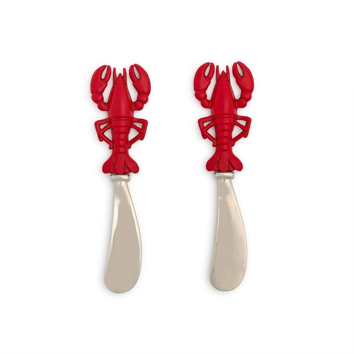 Two red lobster-shaped cutlery pieces resting on a white surface, showcasing their unique design and vibrant color.