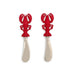 Two red lobster-shaped cutlery pieces resting on a white surface, showcasing their unique design and vibrant color.
