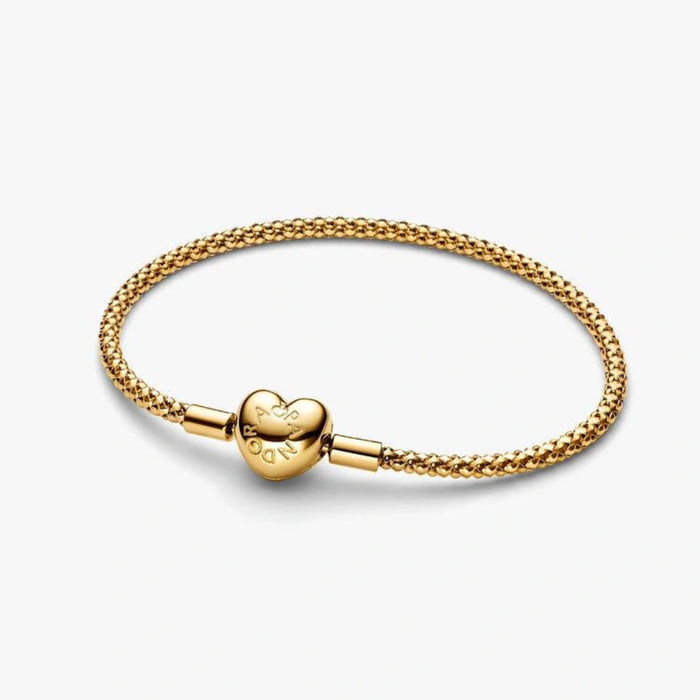 Gold-tone woven mesh chain bracelet with a polished heart-shaped clasp displayed on a white background, perfect for charms and everyday wear.