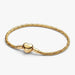 Gold-tone herringbone snake chain bracelet with a polished heart-shaped clasp designed for everyday wear and compatible with charms.