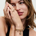A woman showcases a gold bracelet and necklace, reflecting her refined taste in accessories.