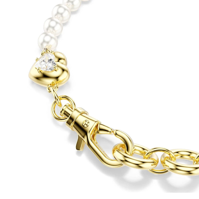 A stylish gold-plated bracelet with white pearls and a heart charm, combining elegance and charm in one piece.