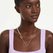A shimmering gold chain complemented by a pearl clasp, representing timeless beauty in jewelry.