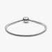 Sterling silver snake chain bracelet with a polished barrel clasp displayed on a white background, designed for everyday wear and compatible with charm beads.