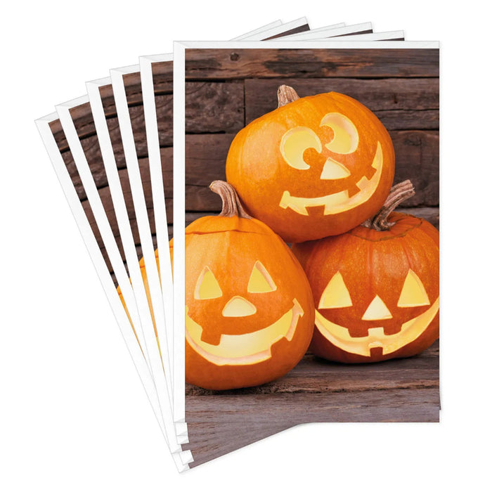 Hallmark Jack-o'-Lantern Trio Halloween card featuring three smiling pumpkins on a rustic wood-plank background.