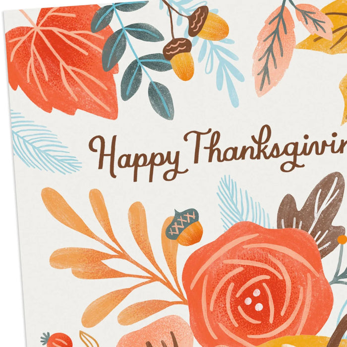 Thanksgiving greeting card featuring a harvest pumpkin, colorful autumn leaves, and floral accents for seasonal celebrations.