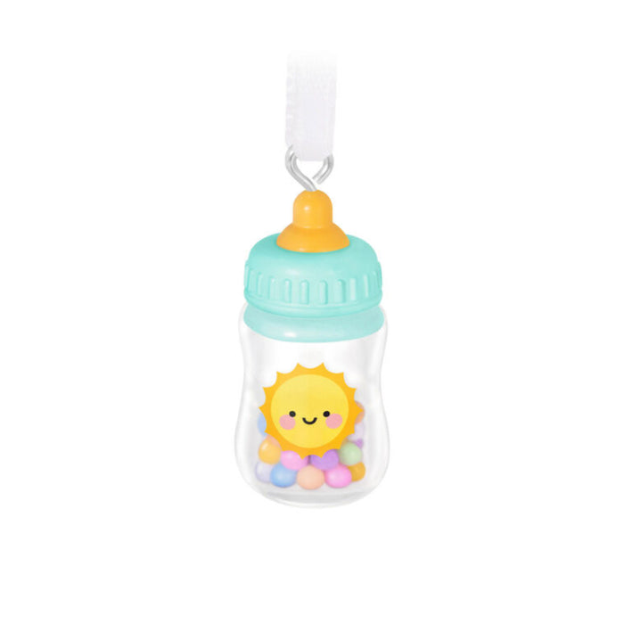 Decorative baby bottle ornament with a sun design on a white background 