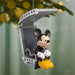 Mickey Mouse hang-glider Christmas ornament hanging from pine branch with golden bokeh holiday lights