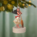 Moana Disney ornament hanging on pine tree holding wooden paddle with gold embroidery skirt