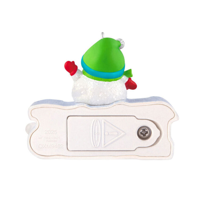 Decorative snowman ornament with a green hat and red mittens on a white 2025 light up sign