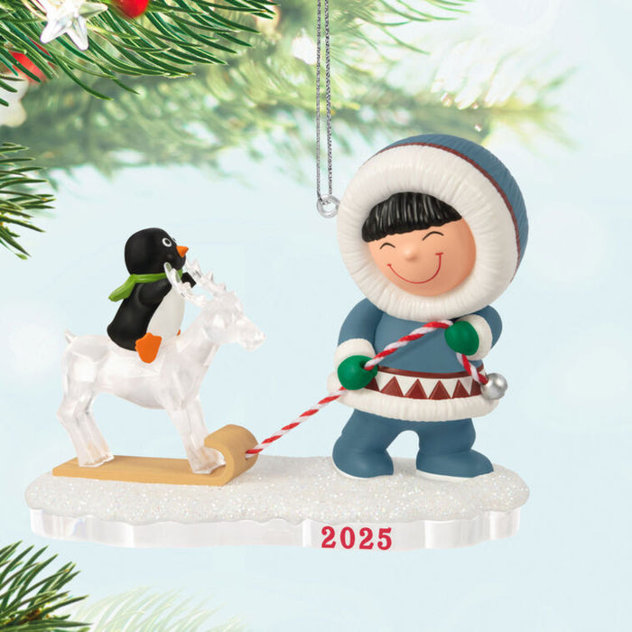 Christmas ornament with a child pulling a penguin on a ice reindeer on a sleigh, Hanging on a tree