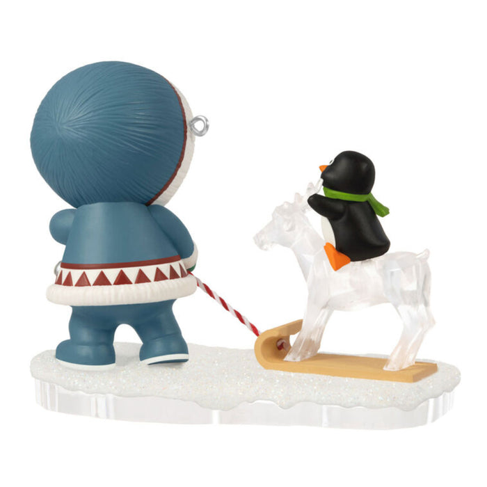 Backside of Christmas ornament with a child pulling a penguin on a ice reindeer on a sleigh, on a white background 