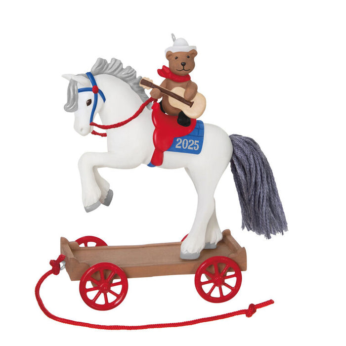 Christmas ornament of  a horse on a  cart, featuring a bear rider playing a guitar on a white background. 
