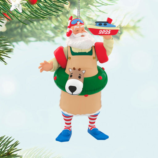 Decorative Holiday  ornament of a Santa Claus figure with a reindeer floatie, holding a boat labeled '2025', hanging on a tree