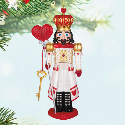 Decorative Christmas ornament of a  king holding hearts and a key, hanging on a tree.