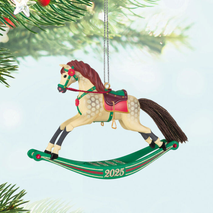 Christmas ornament of a  beige rocking horse with '2025'  hanging from a tree