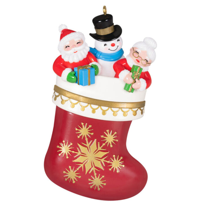 Christmas ornament with Santa, snowman, and reindeer on a red stocking with gold snowflakes. on a white background 