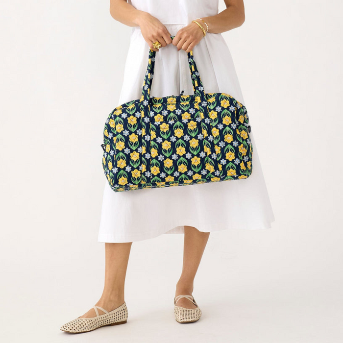 Person holding Vera Bradley Miramar Weekender in Daffodils – quilted cotton floral weekender bag with spacious interior and zipper closure.