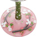 Decorative wine glass base with cherry blossom design on a white background