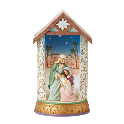 Decorative Jim Shore Figurine nativity scene in a house-shaped container with a star on top light on .