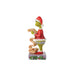 Right side view of  Jim Shore Grinch figurine in a red outfit and Santa hat holding a list, on a white background