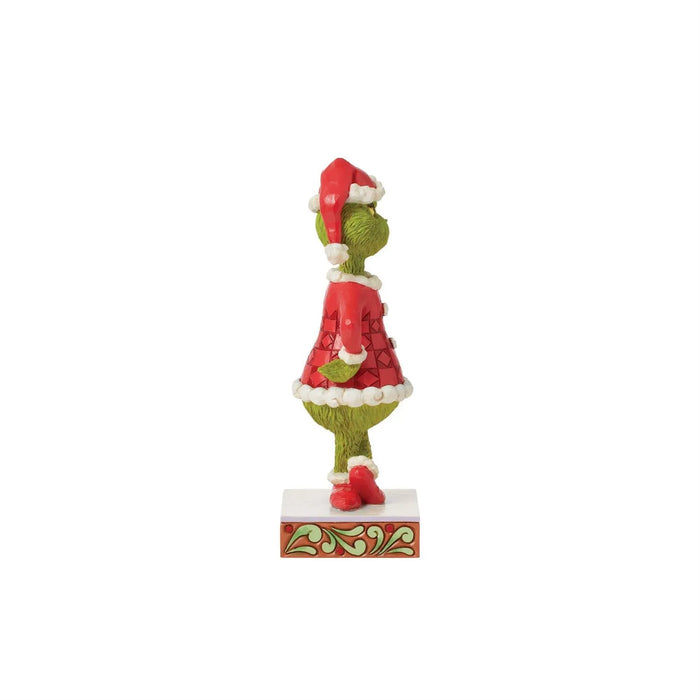 Left side view of Jim Shore Grinch figurine in red patchwork Santa suit, showing detailed hand-painted design on stage on a white background."